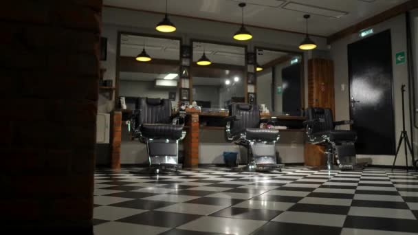 Vintage hanging lamps in hairdressing salon. Ceiling retro lamp in barber shop. Barber pole. Hair salon interior. Metal ceiling lights in barbershop — Stock Video