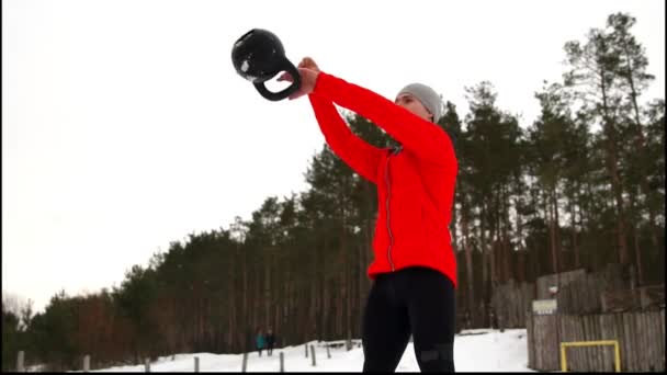 Esportista atraente com exercício de sino de chaleira na aptidão ao ar livre inverno e neve — Vídeo de Stock