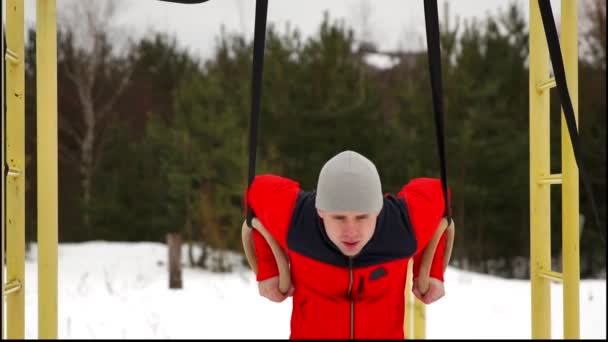 Músculo ups anéis homem balançando exercício ao ar livre inverno — Vídeo de Stock