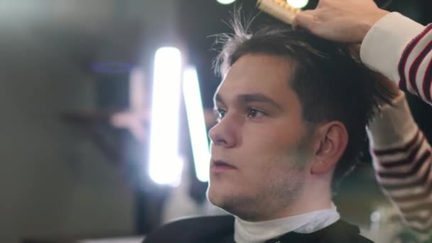 Hairdresser cutting hair with professional scissors and comb in hairdressing salon. Close up haircutter making male haircut with scissors in hairdressing school