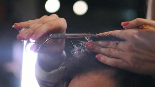 Gros plan, maître coiffeur fait coiffure et style avec ciseaux et peigne. Concept Barbershop. — Video