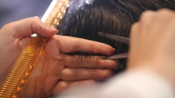 Barbeiro corta o cabelo na barbearia. Movimento Lento. Fechar — Vídeo de Stock