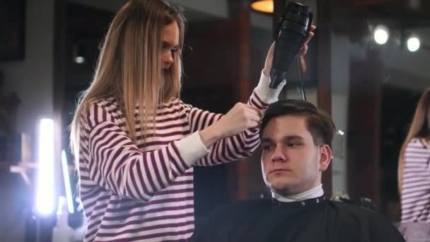 Fryzjer, suszenie włosów mężczyzn w salon fryzjerski. Bliska dmuchanie włosów człowieka z suszarka w barbershop Fryzjer. Mężczyzna hairstylish robi fryzurę w studio urody — Wideo stockowe