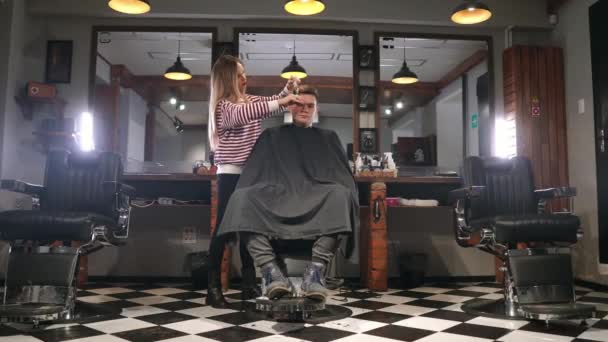 Haidresser や理髪店でヘアスタイリストを訪問男性クライアントの背面図. — ストック動画