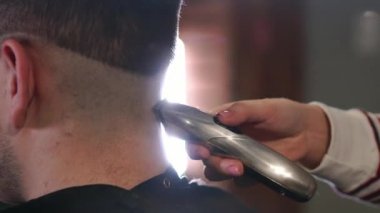 Erkek saç kesimi ile tıraş. Düzeltici saç yakın çekim. Profesyonel kuaför kesim saç saç kesme makinesi ile. Adam kuaförlük ile Elektrikli tıraş makinesi