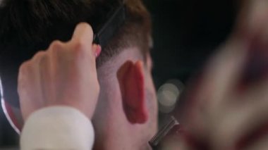 Erkek saç şekillendirme ile profesyonel düzeltici bir kuaför dükkanında yakından görmek. Kuaför Salonu Elektrik kesme makinesi ile kanununu mans. Saç bakım.