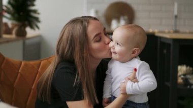 Anne ve bebek ağır çekim. Mutlu bir aile. Anne çocuğunu gülümseyen ve evde gülme ile.
