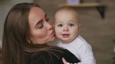 Onun yeni doğan çocuk ağır çekim tutan genç anne. Noel için ev, anne ve bebek çocuk, Aile