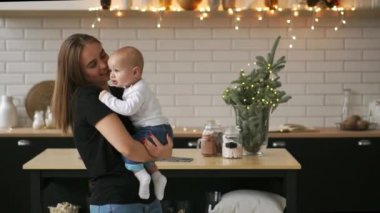 Anne ve bebek ağır çekim. Mutlu bir aile. Anne çocuğunu gülümseyen ve evde gülme ile.