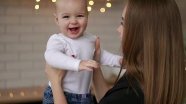 Anne ve bebek ağır çekim. Mutlu bir aile. Anne çocuğunu gülümseyen ve evde gülme ile.
