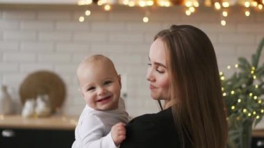 Anne ve bebek ağır çekim. Mutlu bir aile. Anne çocuğunu gülümseyen ve evde gülme ile.