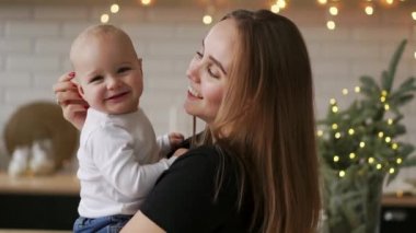 Onun yeni doğan çocuk ağır çekim tutan genç anne. Noel için ev, anne ve bebek çocuk, Aile