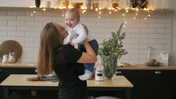 Ung mamma håller hennes nyfödda barnet slowmotion. Familj på hem, Mamma och baby boy i julklapp — Stockvideo