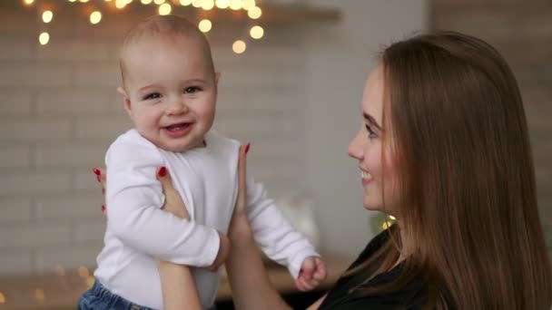 Ung mamma håller hennes nyfödda barnet slowmotion. Familj på hem, Mamma och baby boy i julklapp — Stockvideo