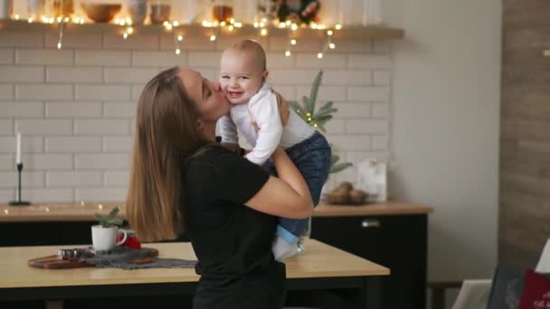 Ung mamma håller hennes nyfödda barnet slowmotion. Familj på hem, Mamma och baby boy i julklapp — Stockvideo