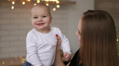 Anne ve bebek oğlu eğleniyor ve evde oynamak. Küçük çocuk 2 yaş oyun anne kollarını ile evde büyük bir pencere yakınında