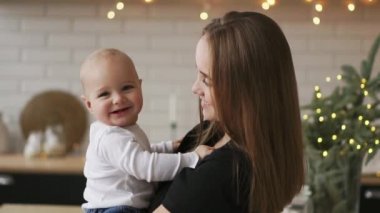 Anne ve bebek oğlu eğleniyor ve evde oynamak. Küçük çocuk 2 yaş oyun anne kollarını ile evde büyük bir pencere yakınında