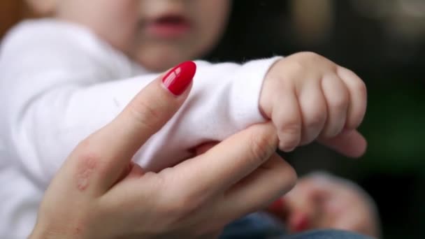 Cuidar a la madre con el bebé, Concepto de amor y familia. manos de la madre y el bebé de cerca, de la mano. Cuidado de madre. Jugando con el bebé en casa. Moción lenta — Vídeo de stock