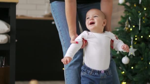 Ребёнок делает первые шаги с помощью матери — стоковое видео