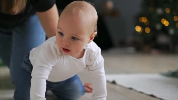 Criança com brinquedo na boca a rastejar no sofá. Close up de bebê nu em fraldas andando na cama com brinquedo. Caminhada engraçada de aprendizagem infantil. Bebê bonito rastejar em casa. Brincadeira de criança doce — Vídeo de Stock