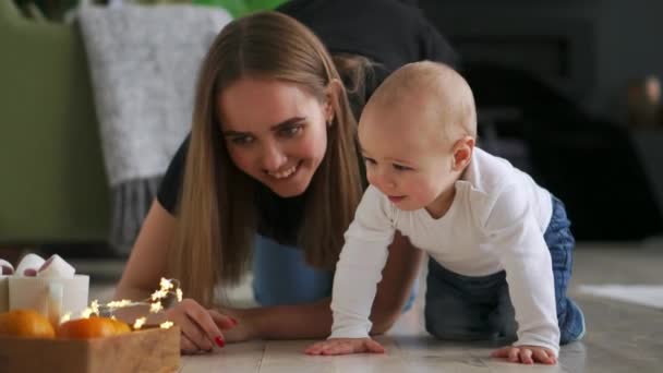 Płacz ładny chłopczyk, siedząc na podłodze w domu a następnie indeksowania do jej mama — Wideo stockowe