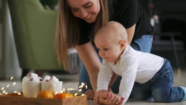 Chorando menino bonito sentado no chão em casa e, em seguida, rastejando para sua mãe — Vídeo de Stock