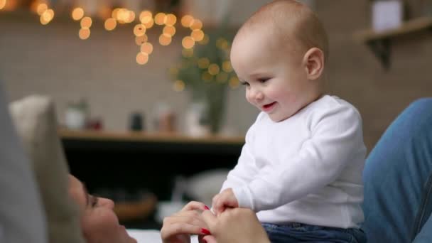 In den besten Momenten des Lebens umarmt eine liebevolle, glückliche junge Mutter einen stillenden Sohn, auf einer schneeweißen Decke, auf weißem Hintergrund. Konzept von Liebe, Familie und Glück: Kinder, Kinder, Baby, Babys — Stockvideo