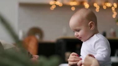 Genç anne yatakta onun bebek çocukla oynuyor