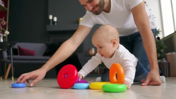 Conceito de família, paternidade e pessoas - pai feliz com o filhinho brincando com brinquedos em casa — Vídeo de Stock