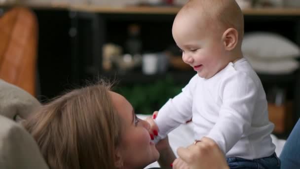 Genç anne yatakta onun bebek çocukla oynuyor — Stok video