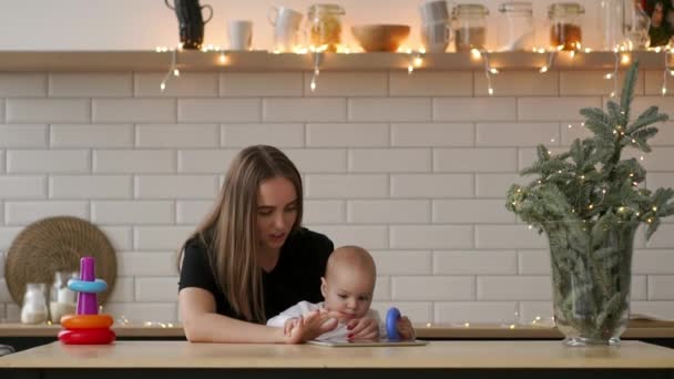 Mère et bébé cherchent à jouer et lire la tablette sur le canapé à la maison — Video