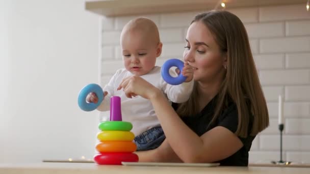 Litet barn flicka och hennes mamma leka med färg leksaker hemma — Stockvideo