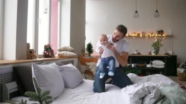 Baba ve sevimli ve güzel çocuk sevinçle aydınlık bir salonda oynuyor