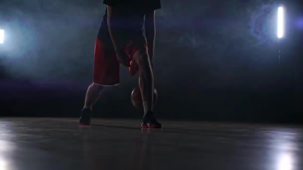 Un jugador de baloncesto en solitario hace algunos movimientos de driblado delante de la cámara — Vídeos de Stock