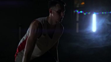 bir genç yetişkin adam, basketbol oyuncu salya topu, karanlık kapalı basketbol sahası. Ağır çekim