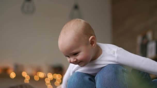 Mama gra z dzieckiem w biały tank top, leżąc na łóżku, dziecko pływające i śmiejąc się. Upływ czasu grania razem matka i dziecko. Symulacja lotu — Wideo stockowe