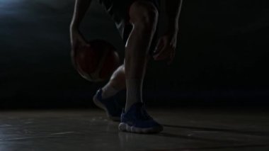 Ağır çekimde duman yakın çekim karanlık odada basketbol oyuncu yakın çekim top sürme