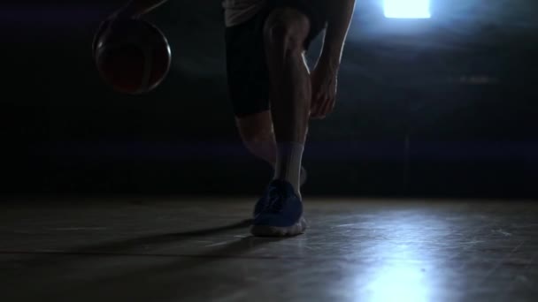 Dribbling jugador de baloncesto primer plano en cuarto oscuro en el humo primer plano en cámara lenta — Vídeo de stock