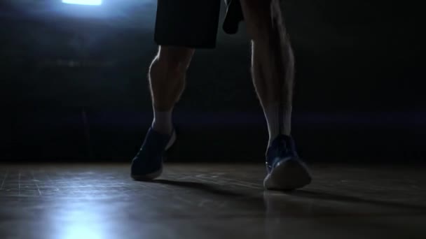Dribbling jogador de basquete close-up no quarto escuro em fumaça close-up em câmera lenta — Vídeo de Stock