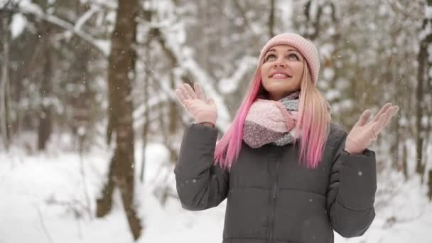 Portrait extérieur de près de jeune belle fille souriante heureuse portant bonnet tricoté blanc chapeau, écharpe et gants. Modèle posant dans la rue. Concept vacances d'hiver . — Video