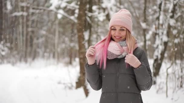 Ευτυχής όμορφη γυναίκα στο casual στυλ τροχαίο με τα χέρια της ενώ χιονίζει στην πλατεία ωραία πόλη στη διάρκεια του χειμώνα. Εξωτερική. Κατακόρυφος βολή — Αρχείο Βίντεο