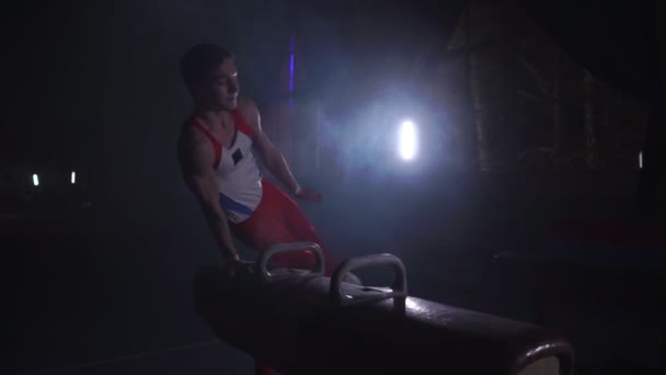 Mužské gymnasta provádí cvičení z olympijského programu na koni našíř provedení otáčí a válců v zpomalené — Stock video