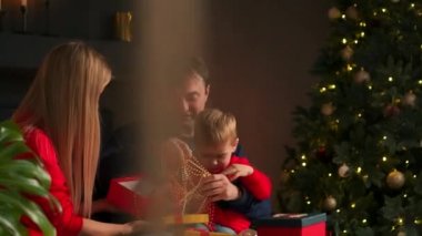 Bir Noel hediyesi hediye açılış mutlu bir aile portresi akşamları kutu. Tatil, e-ticaret online alışveriş, sürpriz, mutlu bir aile kavramı.