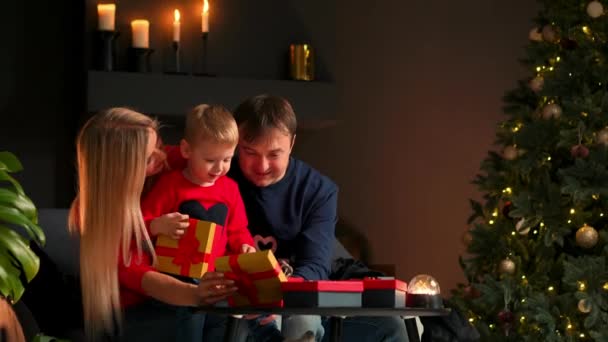 Retrato de familia feliz abriendo una caja de regalo de Navidad por la noche. Concepto de vacaciones, sorpresa, familia feliz, comercio electrónico, compras en línea . — Vídeos de Stock