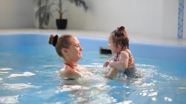 健康な家族の母親は 赤ちゃんスイミングプールを教える — ストック動画