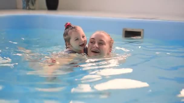 Bonito menino desfrutando com sua mãe na piscina . — Vídeo de Stock