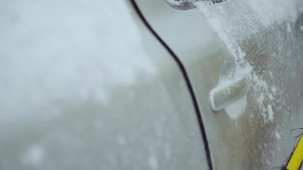 Um grande plano para limpar a neve do carro e abrir a alça da porta no inverno — Vídeo de Stock