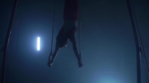 Гимнаст выполняет гимнастические перекрестные упражнения на гимнастических кольцах. Снимок в замедленной съемке . — стоковое видео