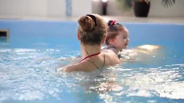 Saludable madre de la familia enseñando piscina bebé — Vídeo de stock
