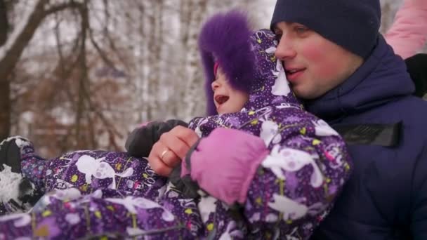 Dad pushes her daughter on a rubber inflatable snow tube in slow motion — Stock Video